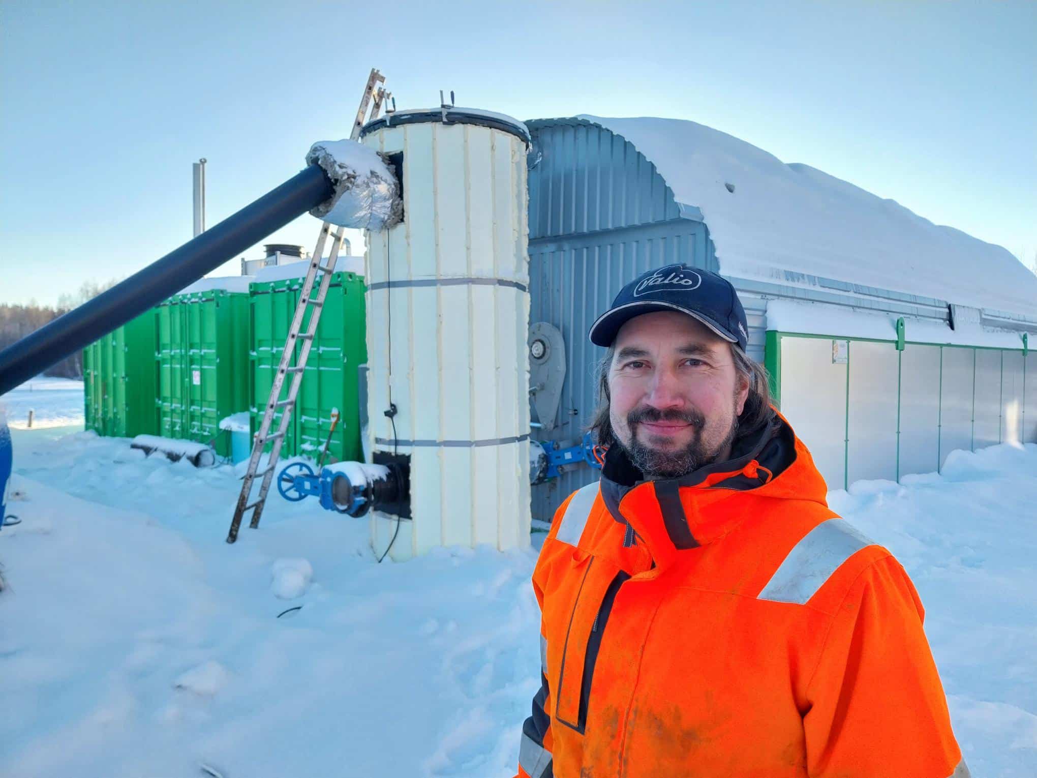 Tero Lahti konttimallisen biokaasulaitoksen edustalla lumisena talvipäivänä.