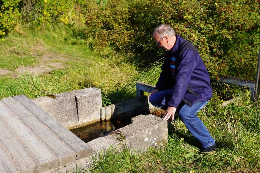 Jukka Tähkiö esittelee sitä, miten lähteen veden pintaa pystyy nostamaan tai laskemaan.