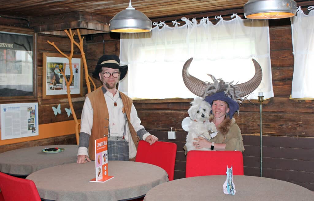 Susanna Lindroth-Qvintus ja Reima Qvintus seisovat kahvilassa. Susannan sylissä on pieni valkoinen koira.