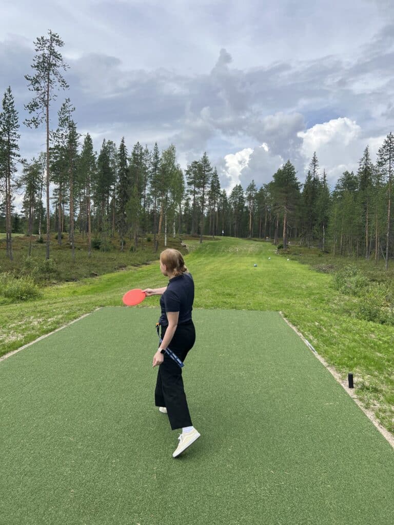 Tyttö heittää frisbeetä.