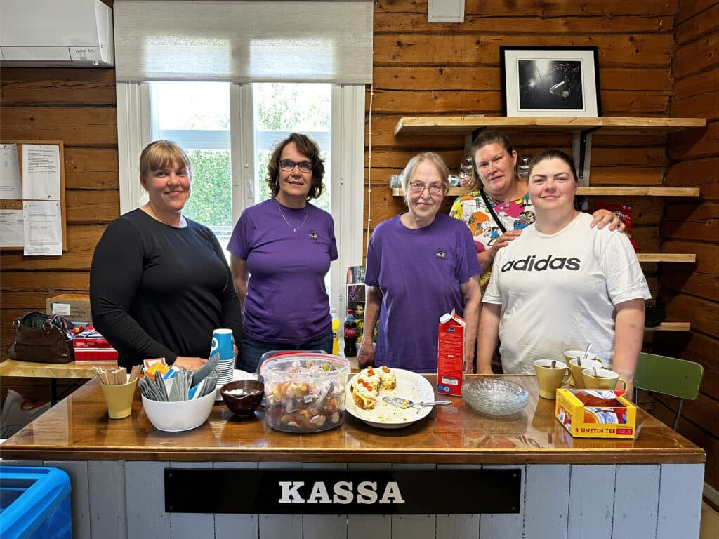 Viisi naista kahvilan tiskin takana.