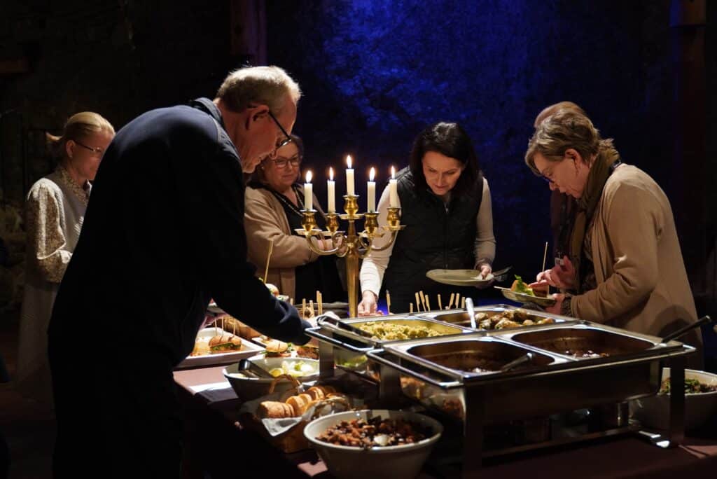 Ihmiset ottavat noutopöydästä ruokaa.