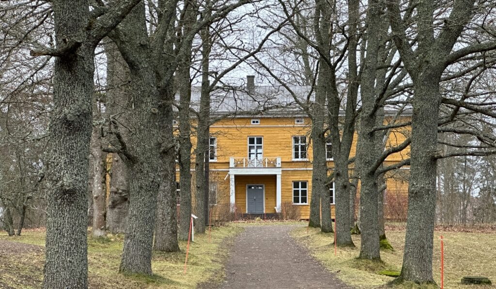 Keltainen Anjalan kartano puukujan päässä