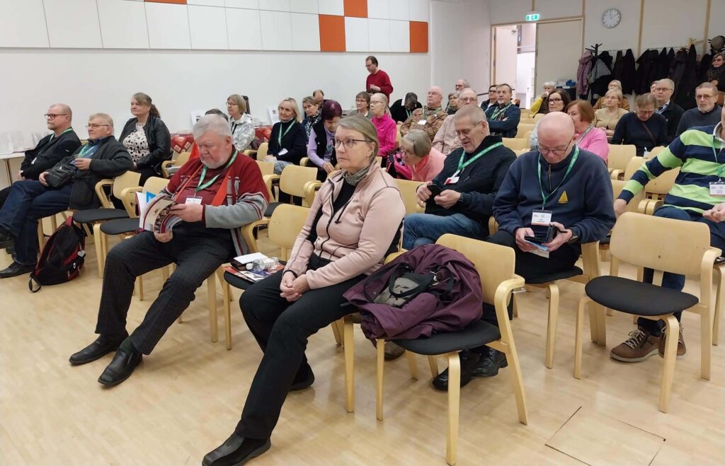 Ihmiset istuvat luentosalissa.