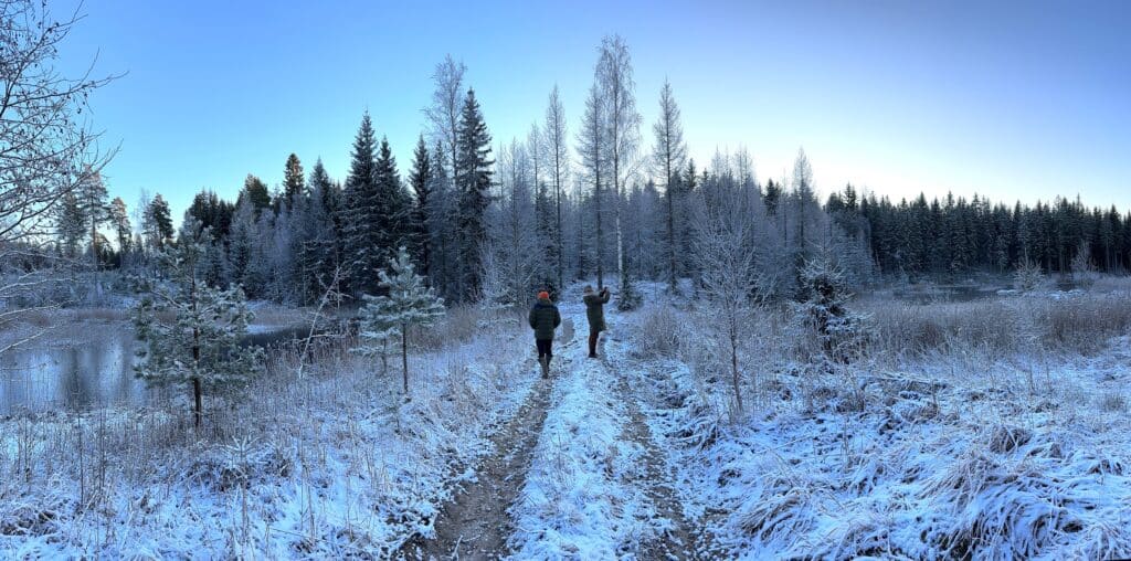 Kaksi ihmistä kosteikkoja välissä olevalla padolla.