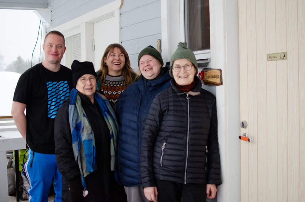 Iloisia yhdistyksen ihmisiä katsoo kameraan