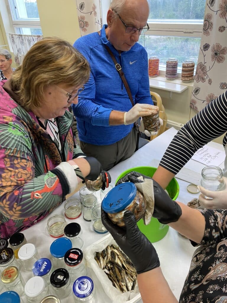 Kuvassa purkitetaan kaloja.