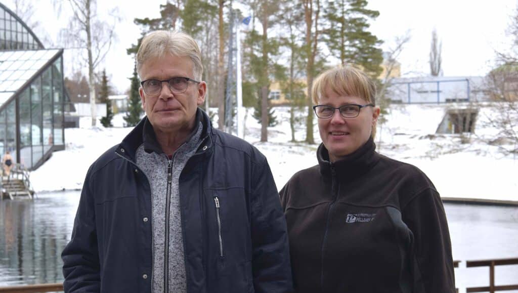 Mies ja nainen, joiden taustalla näkyy Vuoksen uimapaikka.