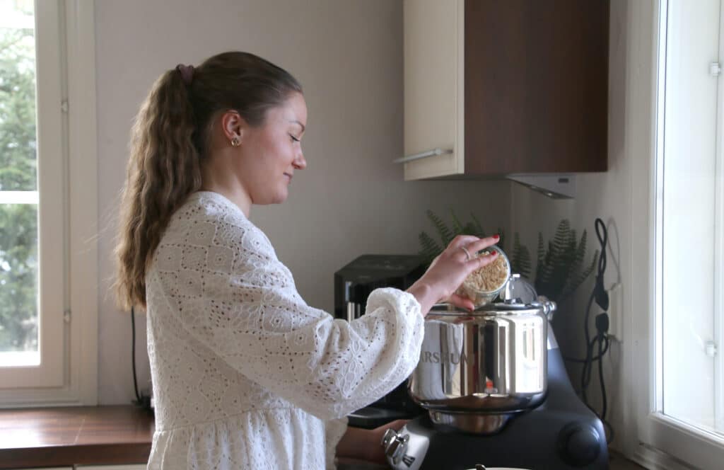 Silpa Kinnunen kotikeittiössään kaataa monitoimikoneeseen aineksia, sillä on tekemässä uusien tuotteiden testausta.