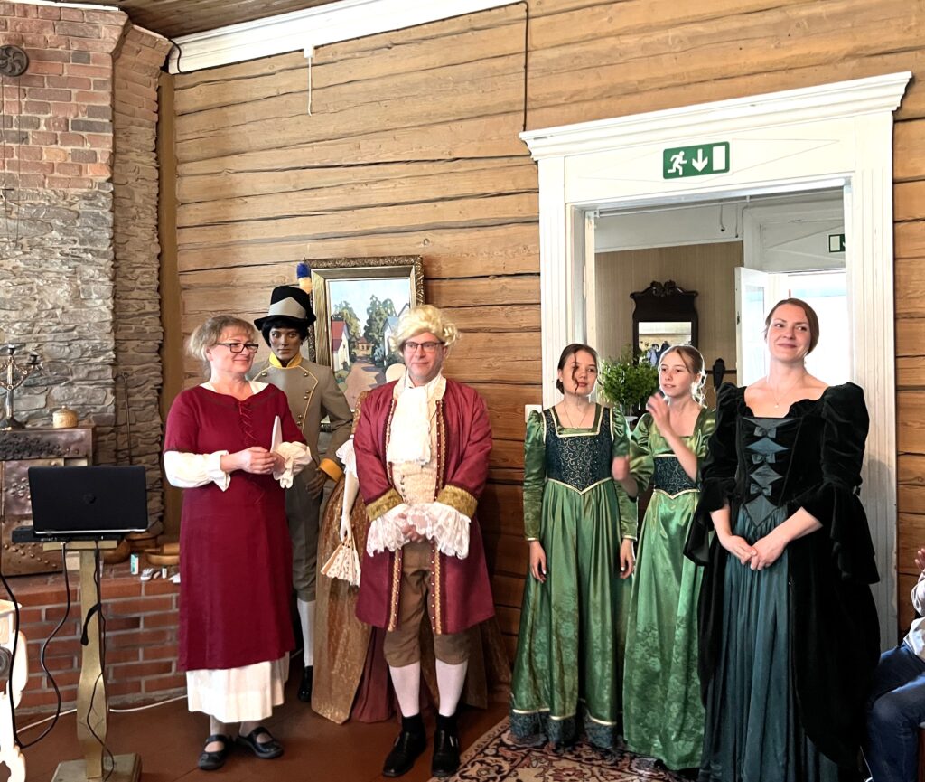 Kuva, jossa ihmisiä 1800-luvun asuissa.