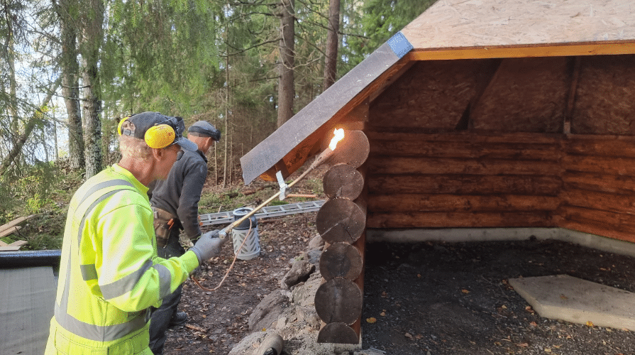 Mies kuullottaa kodan hirsiä