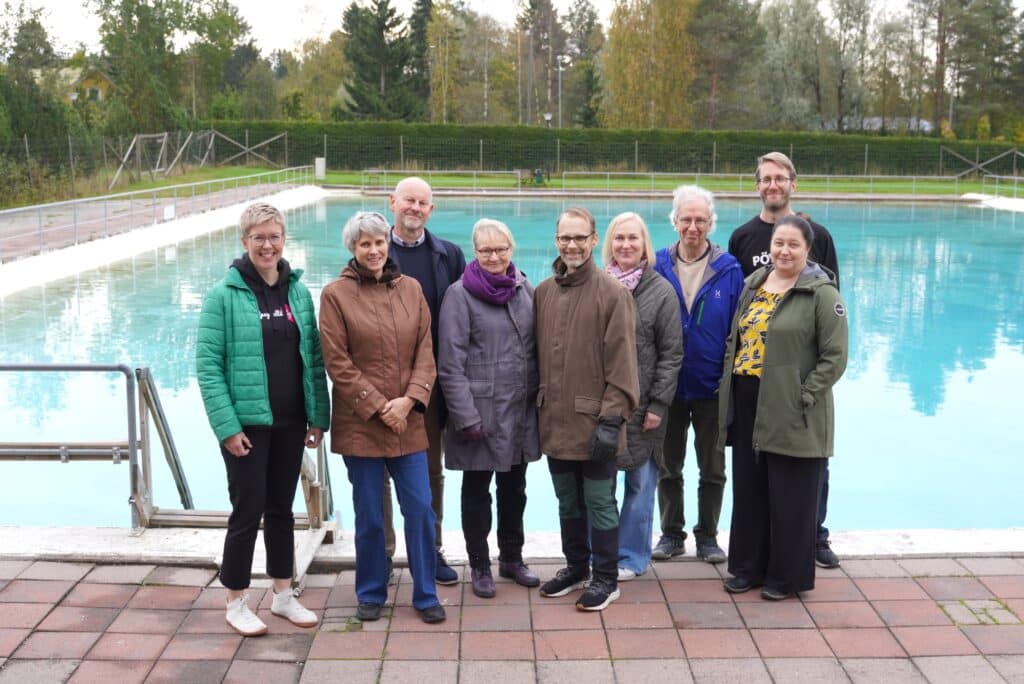 Ryhmäkuva maauimalan altaan edessä.