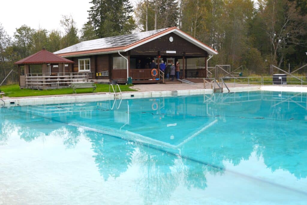 Etualalla uima-allas ja takana saunarakennus.
