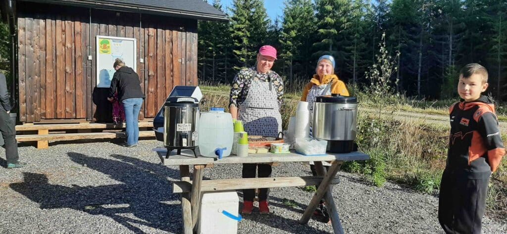 Laavun edustaa, naisia tarjoilemassa keittoa pöydän ääressä.