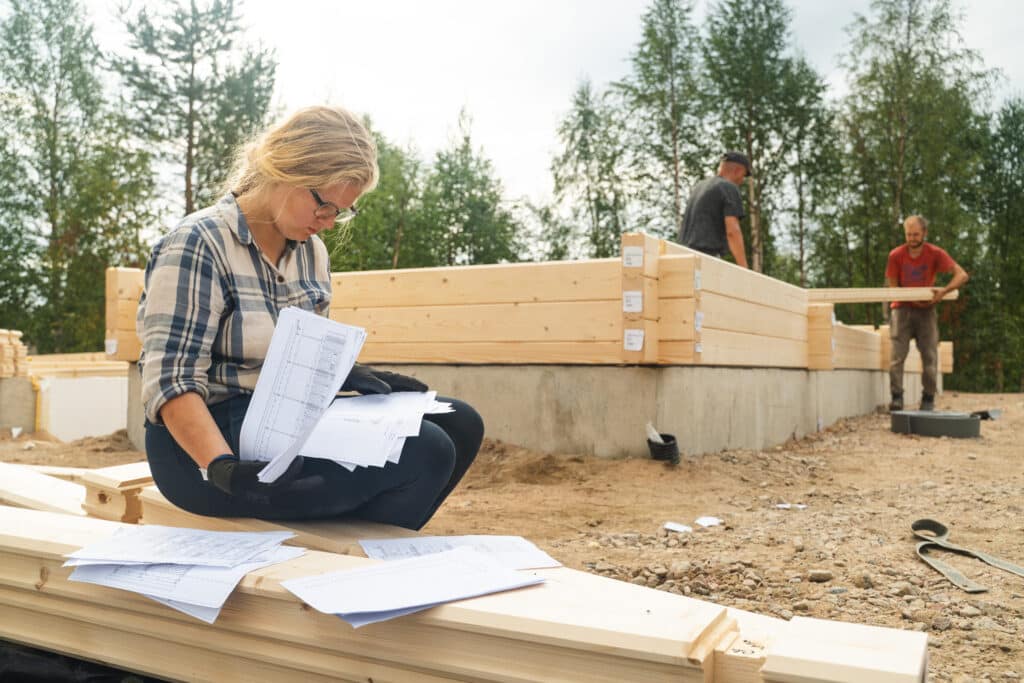 Rakennustyömaata ja nainen kuvassa.