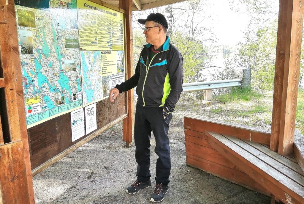 Mies katsoo ulkoilualueen karttaa katoksessa.