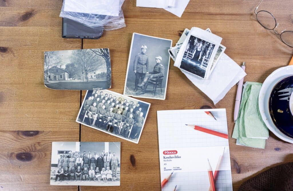 Vanhoja mustavalkoisia valokuvia pöydällä.