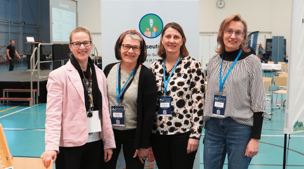 Neljä naista messuosastolla.