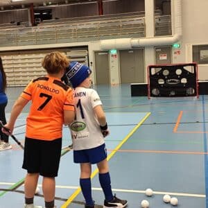 Kaksi lasta selin urheiluhallilla.