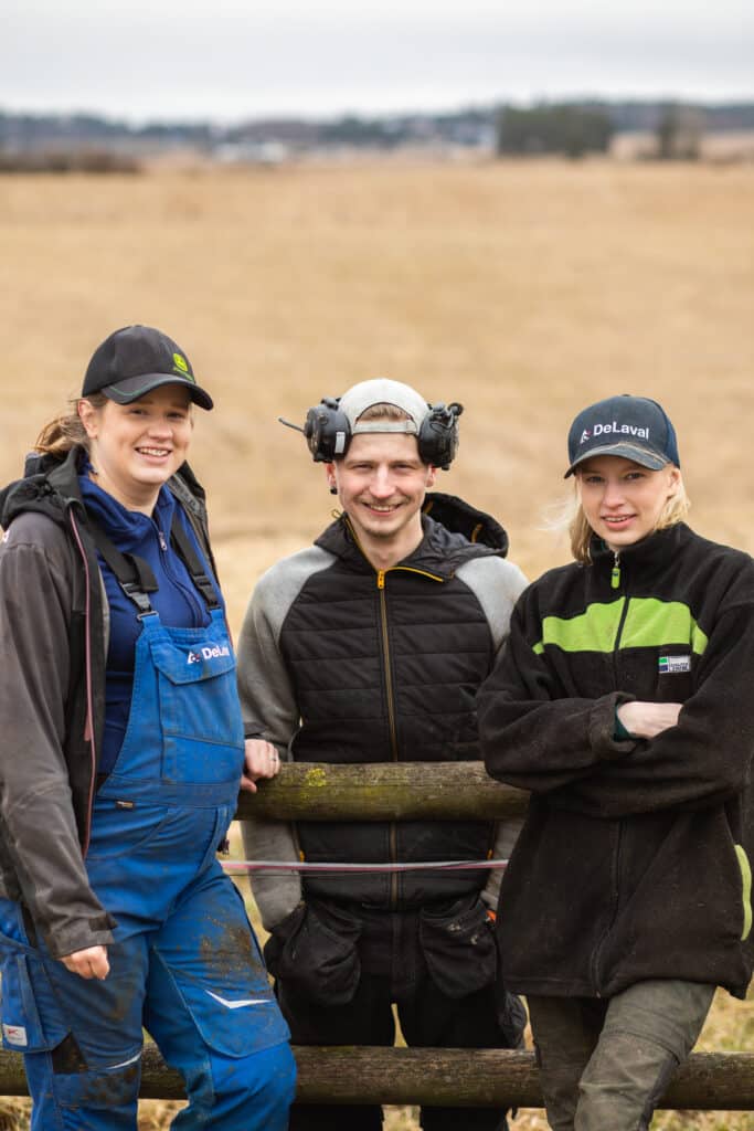 Kolme nuorta seisoo pellon edustalla