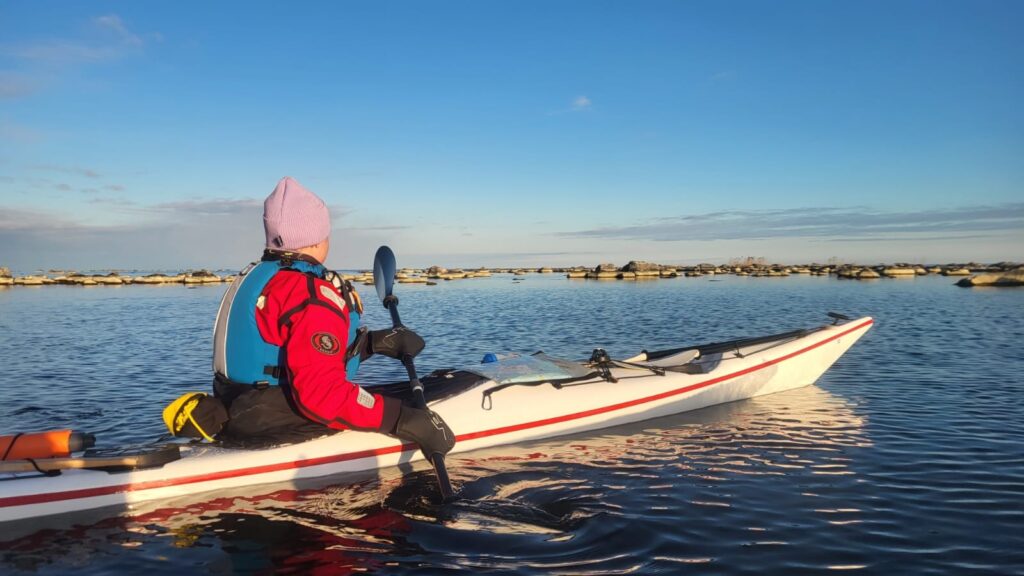 Kanootti melomassa auringonlaskussa. Kanotpaddling i solnedgången