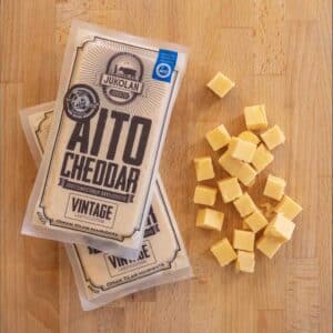 Aito Cheddar Vintage -juustopakkaus ja sen viersessä juustopaloja kuutioina.