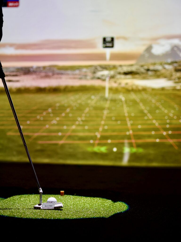 Golfkenttä-simulaatio, etualalla golfmailaa.