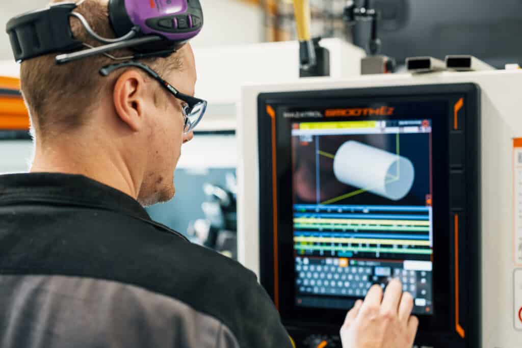 Mies naputtelee teollisuuskoneen kosketusnäyttöä. Copilot said:En man trycker på en industrimaskins pekskärm.